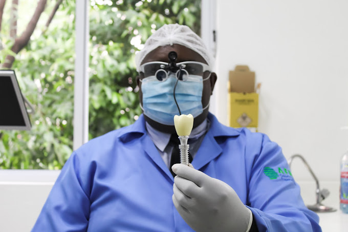 Dr. Alex de Freitas segurando implante dentario